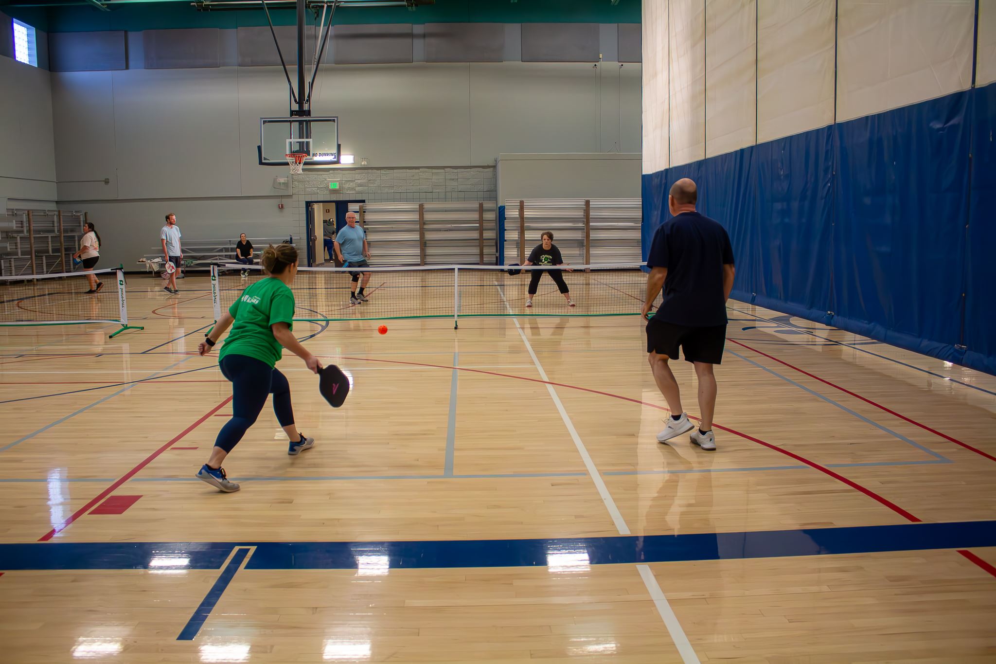 A Pickleball Pair is about to hit the ball back to the other team in our Indoor Pickleball League